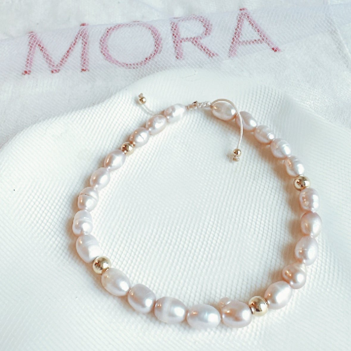 Pulsera ajustable con dijes en oro 18k y perlas